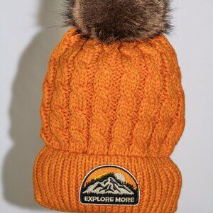 Orange stocking cap with "Explore More" patch and fuzzy lining